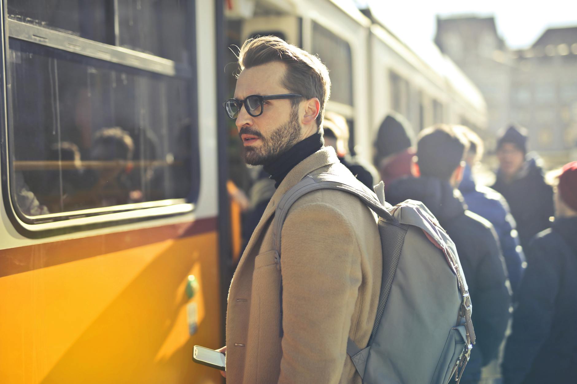 man in brown coat and gray backpack posing for a photo georgefeola.io email marketing ages.