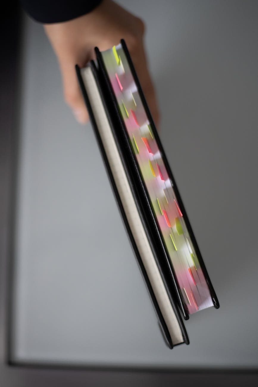 a close up shot of a person holding books. georgefeola.io