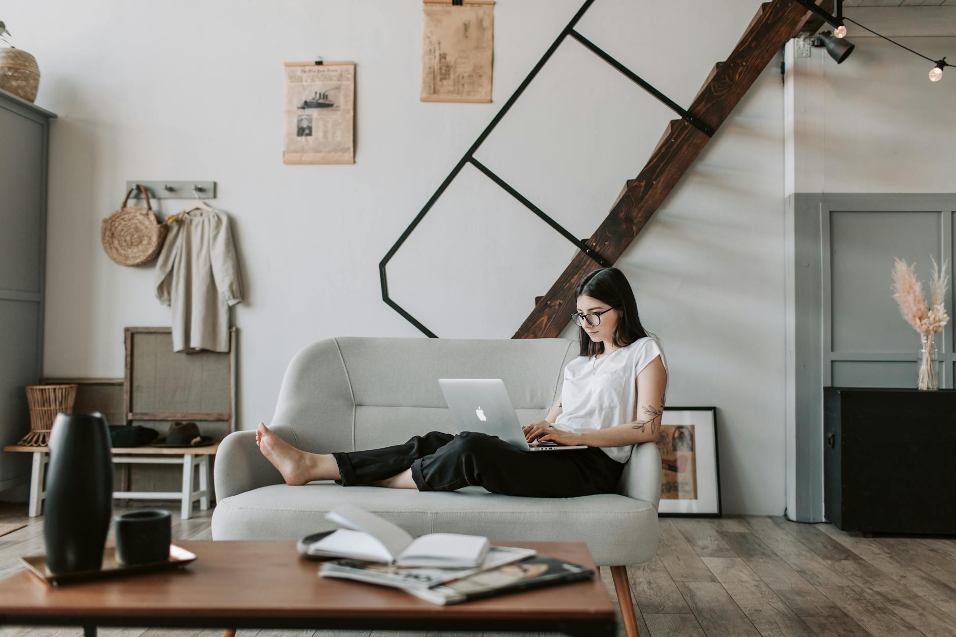 content young woman using laptop in modern living room. Newsletter. george feola dot io.