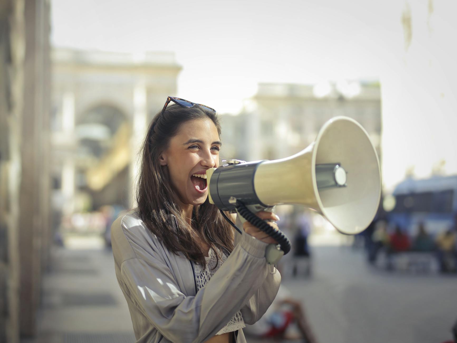 cheerful young woman screaming into megaphone get attention georgefeola.io